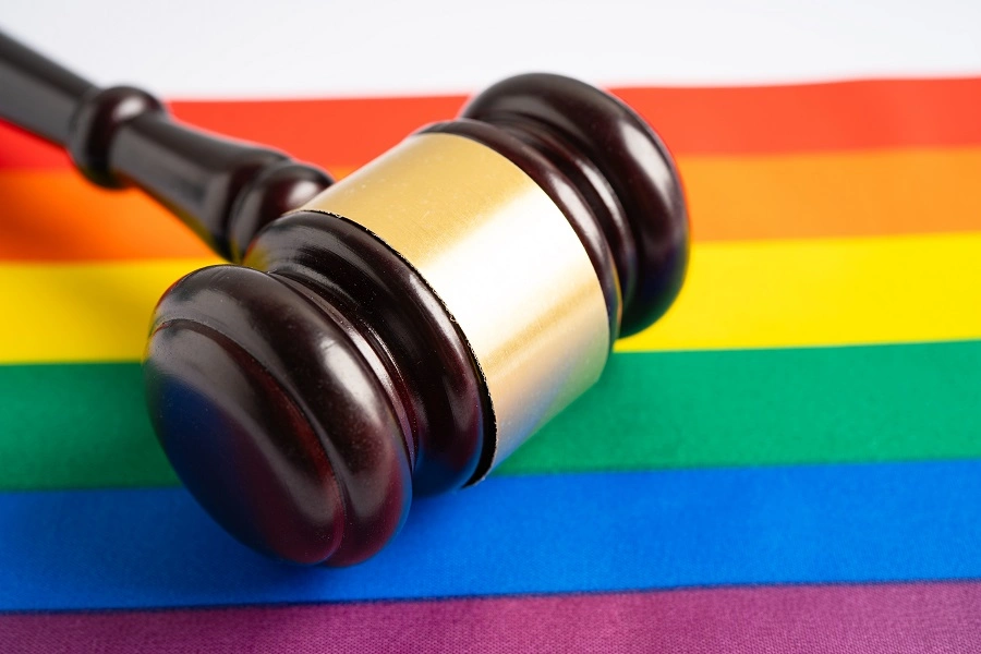 Wooden gavel resting on a rainbow pride flag