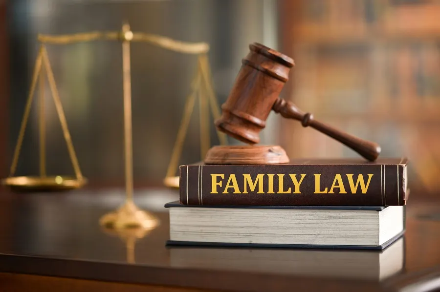 Gavel on a book titled Family Law beside brass scales of justice