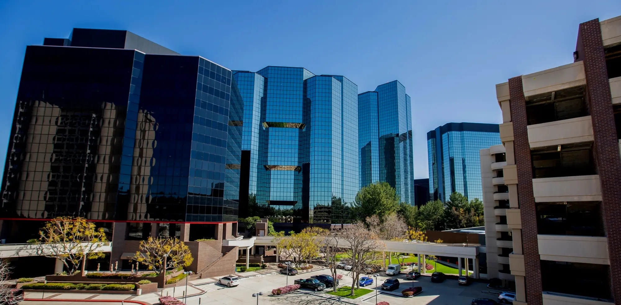 Blue glass office towers beside a parking structure