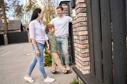 Parents and their son walking together along a residential street