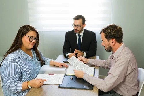 Attorney reviewing documents with a couple at a desk