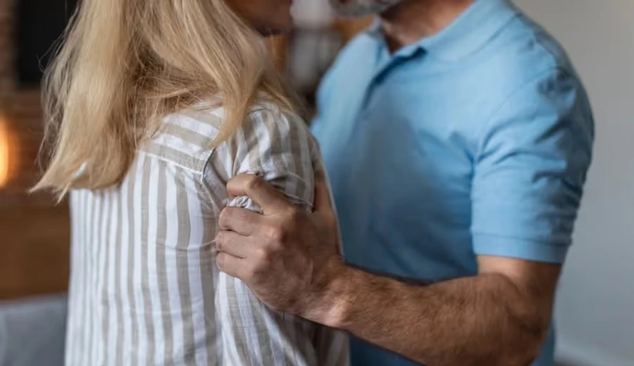Man gripping a woman by the shoulder in a tense confrontation