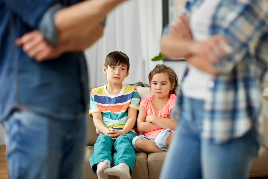 Two children sitting between their parents' crossed arms